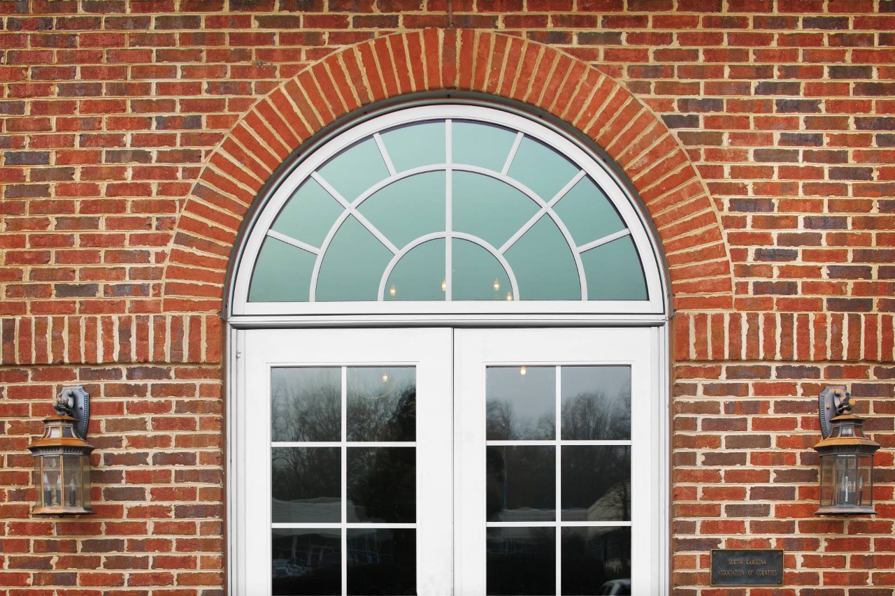 A red brick building with a semi-circle window and French doors at The Blind Guys near Tucson, AZ
